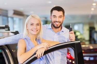 Frau und Autoverkäufer mit Autoschlüssel
